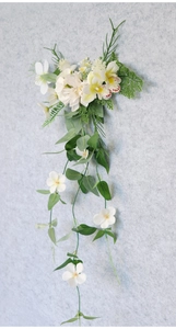Detail of hanging bridal hair accessory with white orchids and greenery foliage
