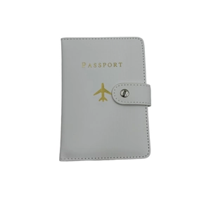 Close-up of white PU leather passport cover with gold plane logo and snap fastener