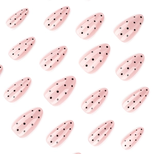 Nude cat eye almond press-on nails with black polka dot patterns in glossy finish