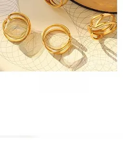 Close-up of geometric gold-plated titanium rings with minimalist layered open design