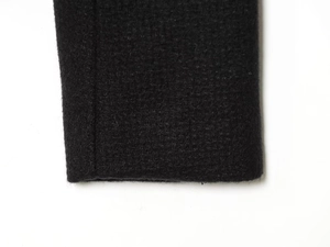 Macro shot of black tweed fabric texture and sleeve detail of slim-fit blazer