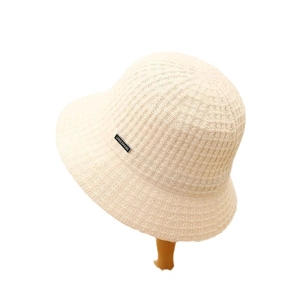 Cream knit bucket hat for women featuring a textured pattern and small branded side label