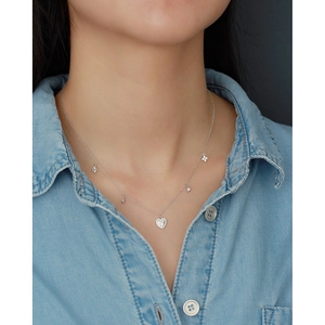 Detail of s925 silver layered necklace with heart and clover zircon pendants on model