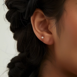 Close-up of S925 sterling silver heart stud earring with clear diamond on cartilage