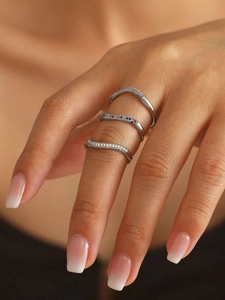 Macro shot of three stacked 18k gold-plated zircon rings worn on female fingers