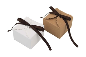 Détail d'une boîte cadeau carrée en kraft avec bord ondulé et nœud de ruban marron
