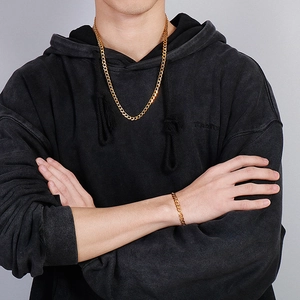 Detailed view of 18K gold plated Cuban chain necklace and bracelet set on a male model