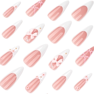 Pink and white French press-on nails with 3D floral and bow accents in long pointed shape