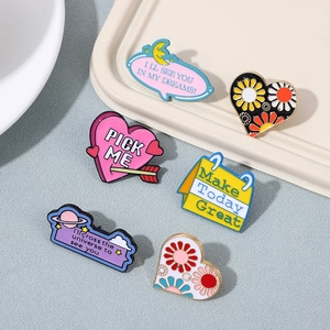 Flat lay of six colorful enamel brooches with English slogans and floral heart designs