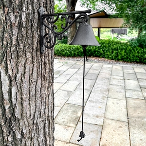 Vintage black cast iron outdoor garden wall bell with decorative scrollwork and pull rope