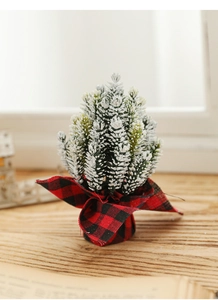 Detailed view of mini snow-flocked Christmas tree with red buffalo plaid fabric base