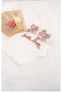White Lolita lace socks with pink bows and rhinestone pearls on a romantic floral background