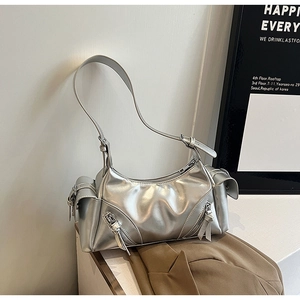 Detail of silver metallic Y2K shoulder bag featuring multi-zipper decor and utility pockets