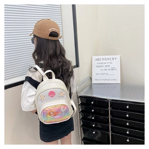 Rear view of a girl wearing a white mermaid backpack with seashell and starfish details