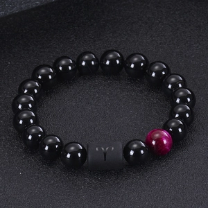 Macro shot of Aries zodiac bead with black onyx and purple tiger eye stones