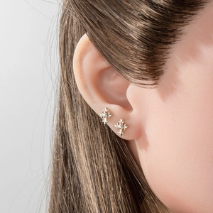 Silver cross fleur-de-lis titanium steel cartilage stud earring worn on model