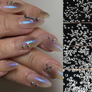 Macro detail of silver nail art studs including mini metal beads and metallic bar accents