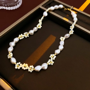 Detail of pearl flower necklace with gold beads on a luxury jewelry tray