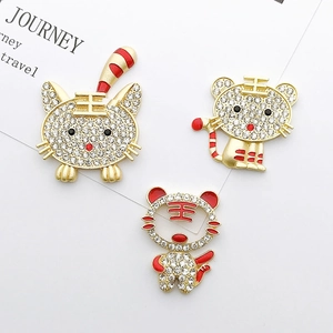 Macro detail of gold tiger charms featuring sparkling rhinestones and red enamel coating