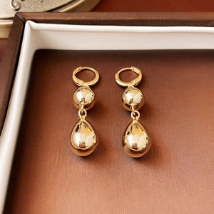 Golden knot rope teardrop earrings in luxury jewelry box with elegant metal texture
