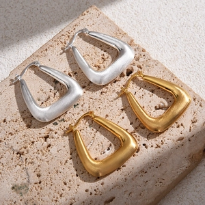 Minimalist brushed metal triangle hoop earrings in gold and silver finish on stone