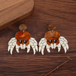 Detailed close-up of brown acrylic spider drop earrings with amber texture for Halloween