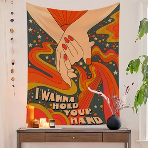 Detail of bohemian tapestry featuring 'I WANNA HOLD YOUR HAND' text and retro sun rays