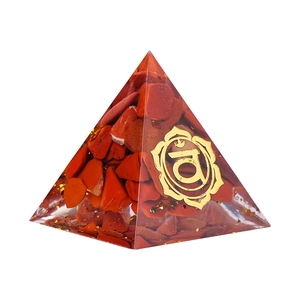 Piramide energetica in resina con cristalli rossi e simbolo chakra dorato