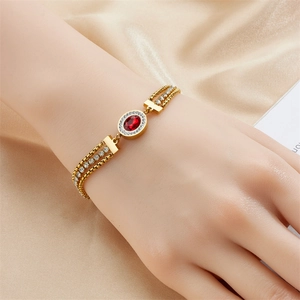 Gold layered chain bracelet with red oval gemstone and white zircon accents on silk