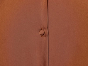 Detailed macro shot of brown satin silk fabric texture and matching fabric-covered button