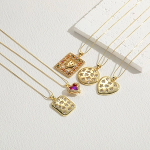 Détail de cinq colliers plaqués or 14 carats avec divers pendentifs géométriques en zircon