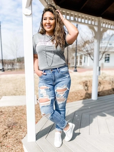 Détail de l'ensemble jean skinny déchiré bleu clair et t-shirt gris imprimé