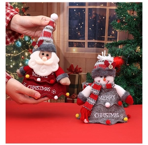 Detail of Christmas gift bags featuring plush Santa Claus and snowman with knitted hats