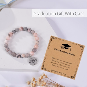 Detail of beaded pink crystal bracelet with compass charm and graduation gift card