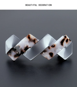 Close-up of geometric acetate hair clip with silver-grey and tortoiseshell wavy pattern