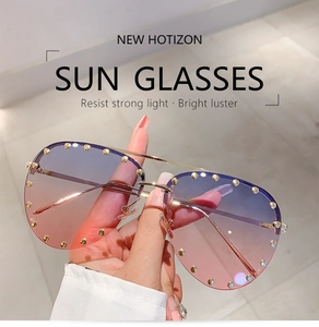 Detailed macro view of trendy half-frame sunglasses with purple gradient lenses and gold studs