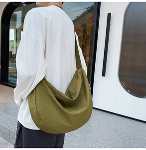 Olive green large capacity crossbody bag made of durable oxford cloth shown on model