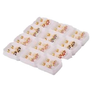 Colorful enamel daisy stud earrings set in gold stainless steel on a white display