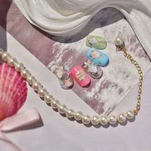 Detailed view of summer ocean style nail stickers with pearls, seashells, and glitter elements