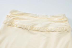 Detail of beige summer set showing layered waist folds and delicate lace trimming