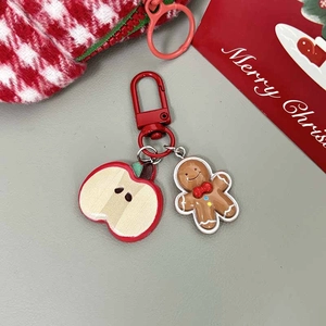 Detailed view of gingerbread man and red apple charms on a festive Christmas keychain