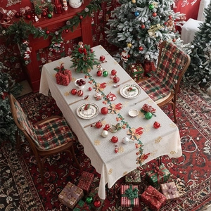 Beige Christmas tablecloth with festive embroidery on a dining table with holiday decor