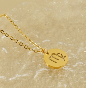 Macro d'un pendentif Vierge doré ajouré avec une chaîne fine en acier inoxydable