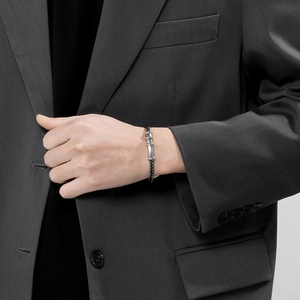 Men's black braided leather bracelet with silver magnetic clasp on model wrist