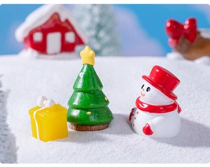 Miniatures de Noël avec boîte cadeau, sapin et bonhomme de neige sur fond de neige