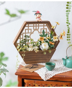 Detalle de cesta de pared hexagonal de madera con flores falsas y pequeña figurilla