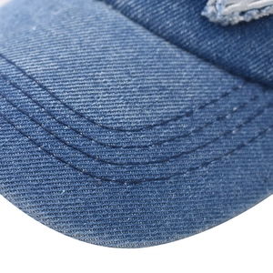 Detail of blue denim baseball cap brim with parallel stitching and vintage washed texture