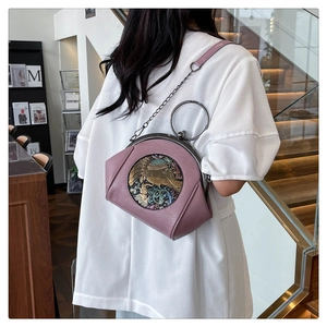Detailed back view of a pink ethnic shell bag with metal chain strap and elephant motif