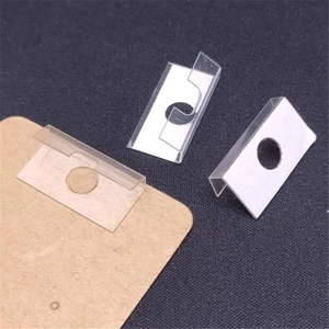 Detail of transparent PVC self-adhesive display hooks on a kraft paper jewelry card