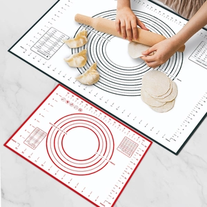 Thickened silicone baking mat with measurements and rolling dough on marble background